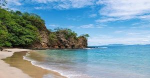 a sandy beach next to a body of water