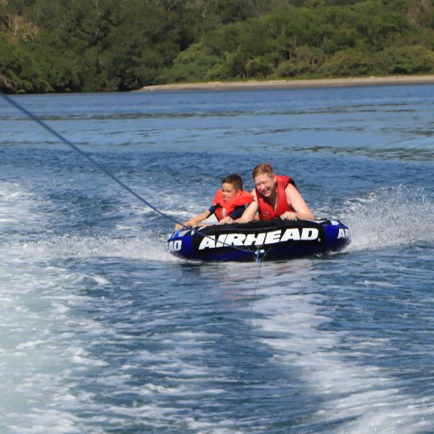 a man riding on the back of a boat in a body of water